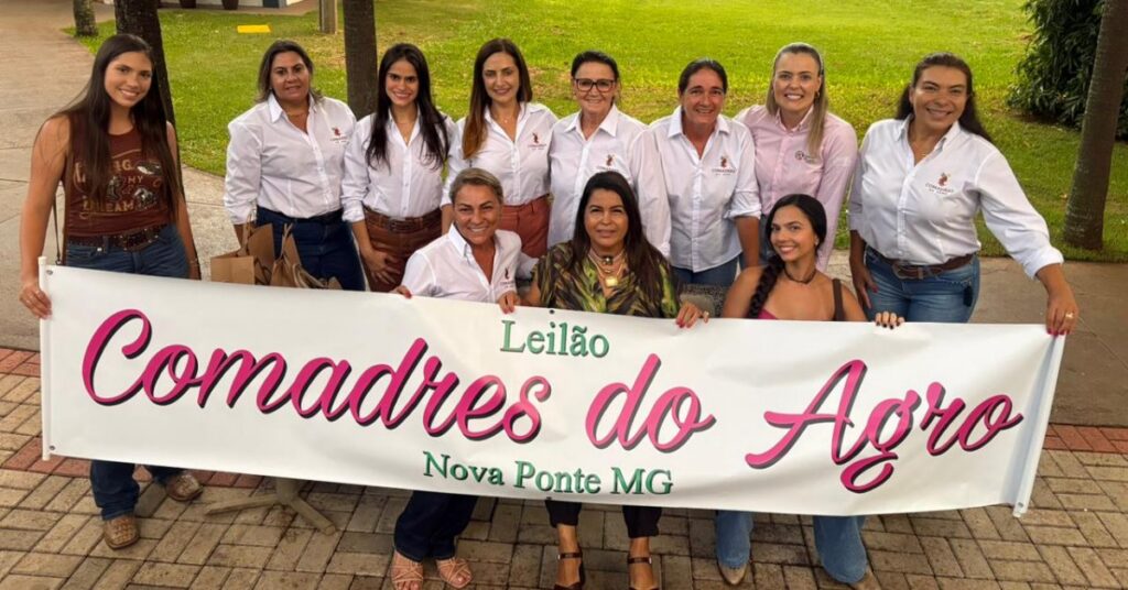 Imagem mostra grupo de mulheres segurando um cartaz escrito Comadres do Agro