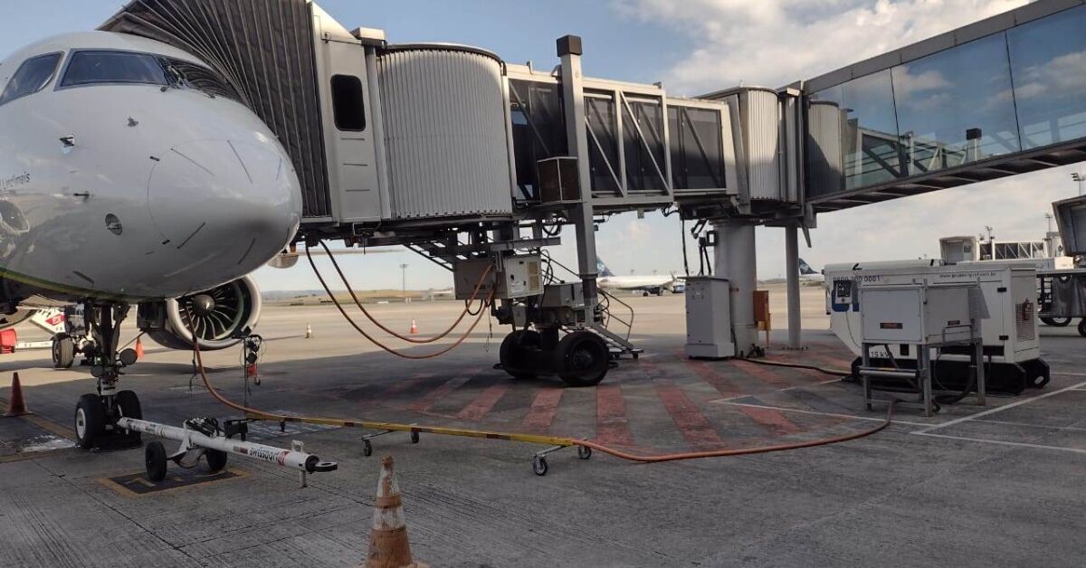 Avião estacionado conectado à ponte de embarque em um aeroporto.