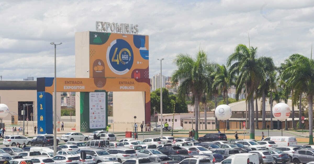 Fachada principal com destaque para o logo do Expominas e estacionamento lotado em frente.